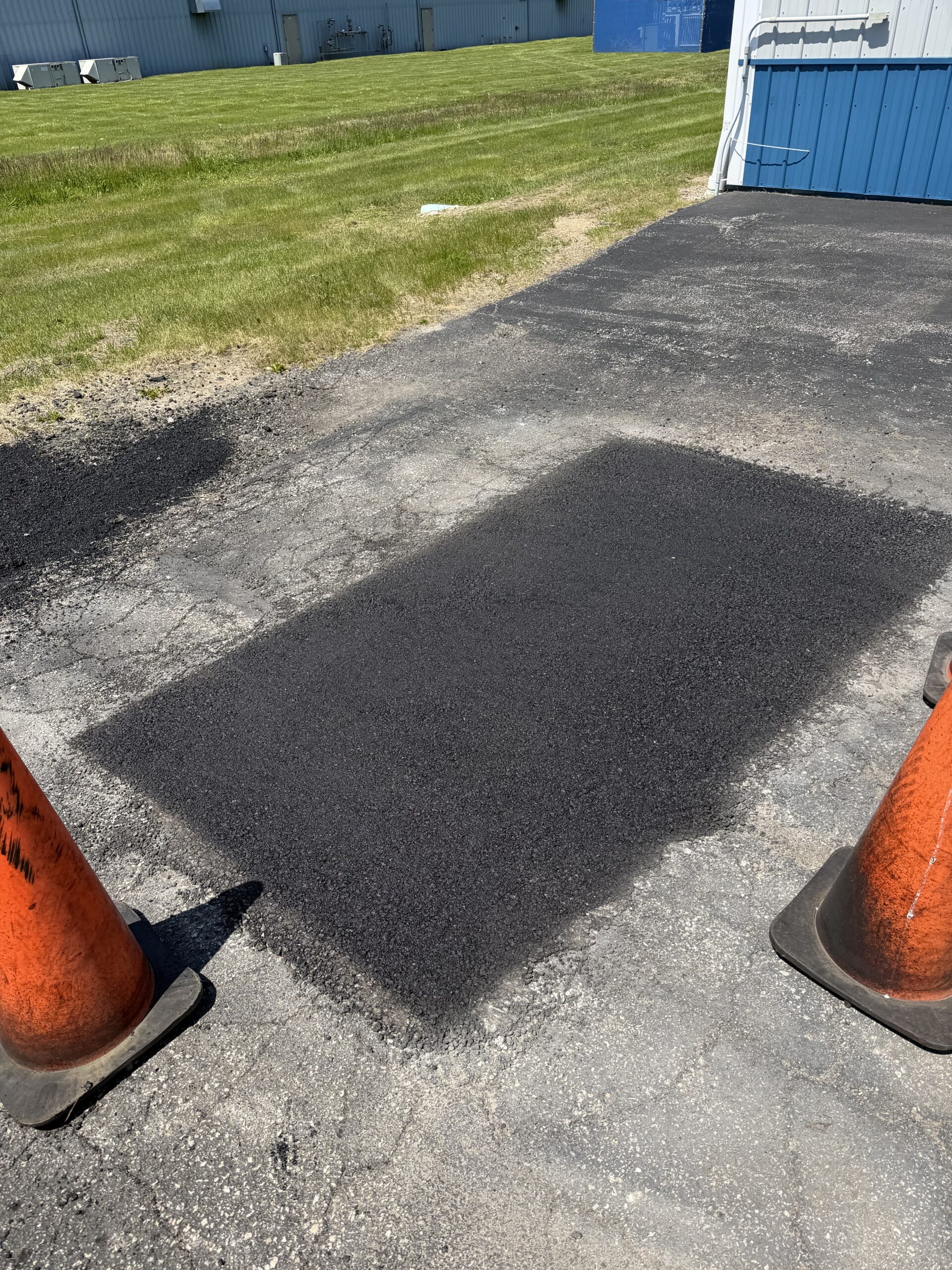 Picture of a section of asphalt that was patched and repaired.